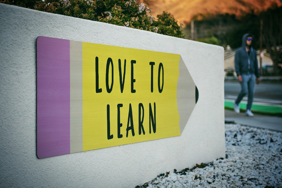 A pencil-shaped sign reading Love to learn