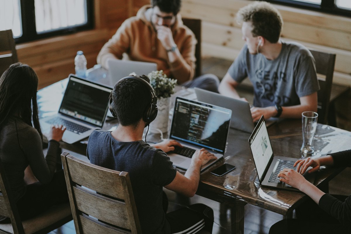 Colleagues working on laptops around a table